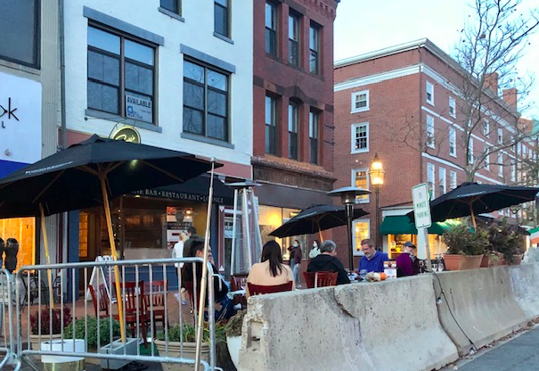 Restaurants using blocked off streets and heaters to create outdoor seating areas.
